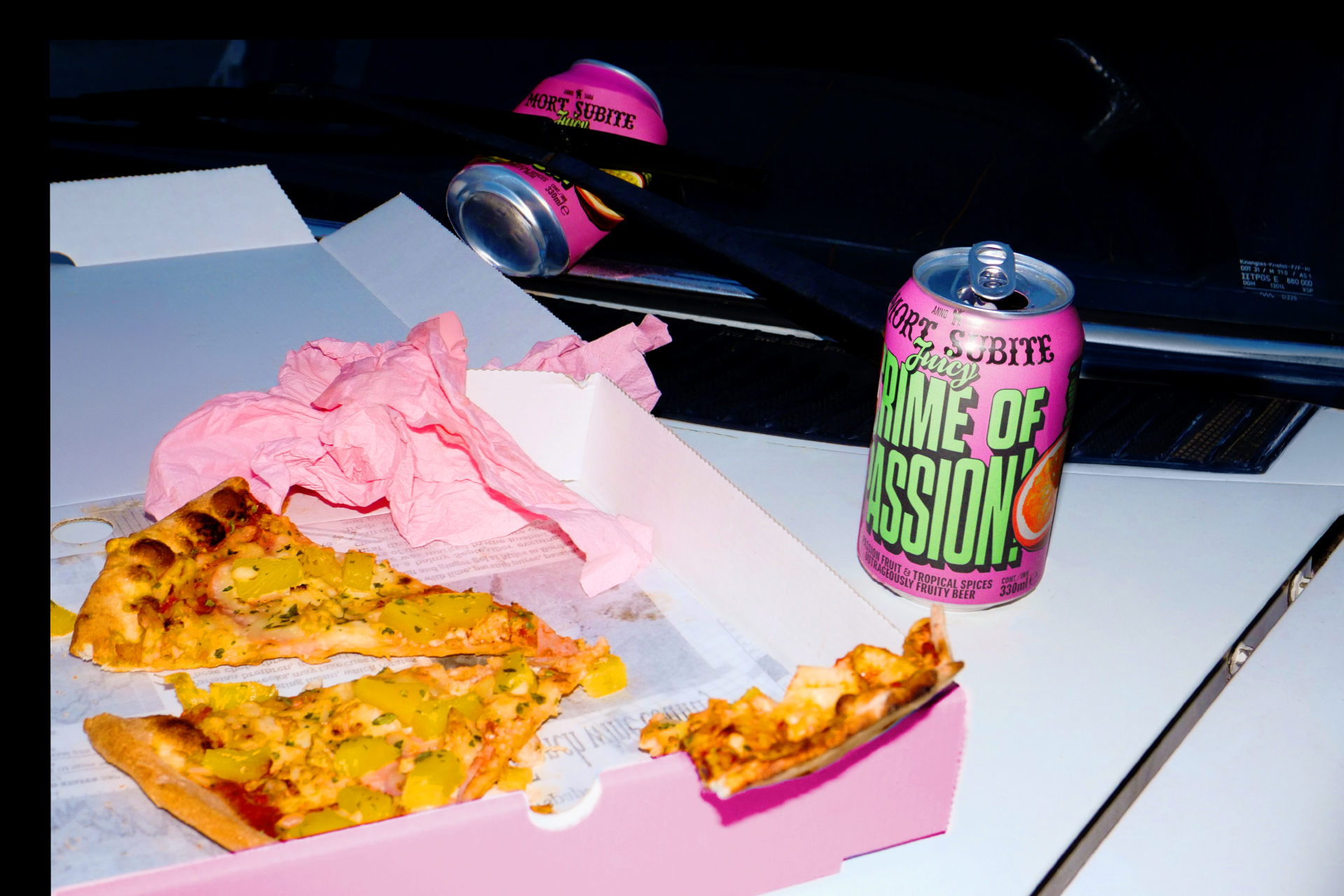 Crime of passion cans next to pizza slices.