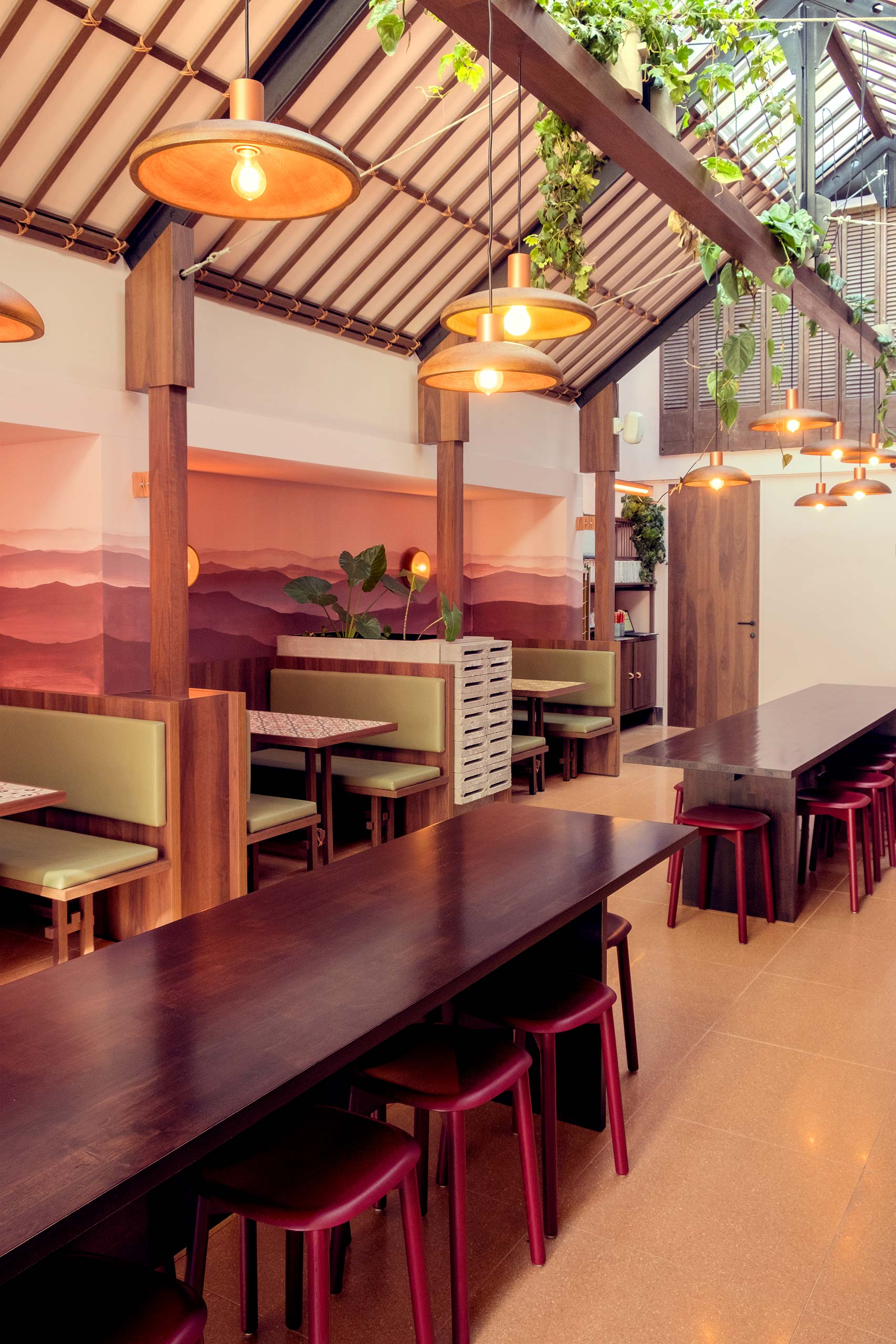 The booth seating of Can Tho and the long tables with red benches.
